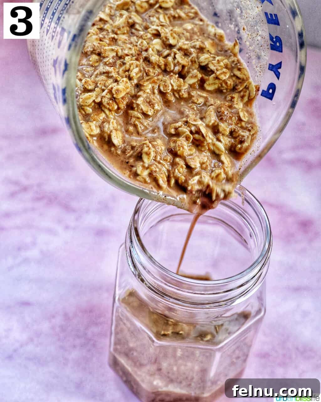 Pouring Biscoff overnight oats ingredients into a mason jar.