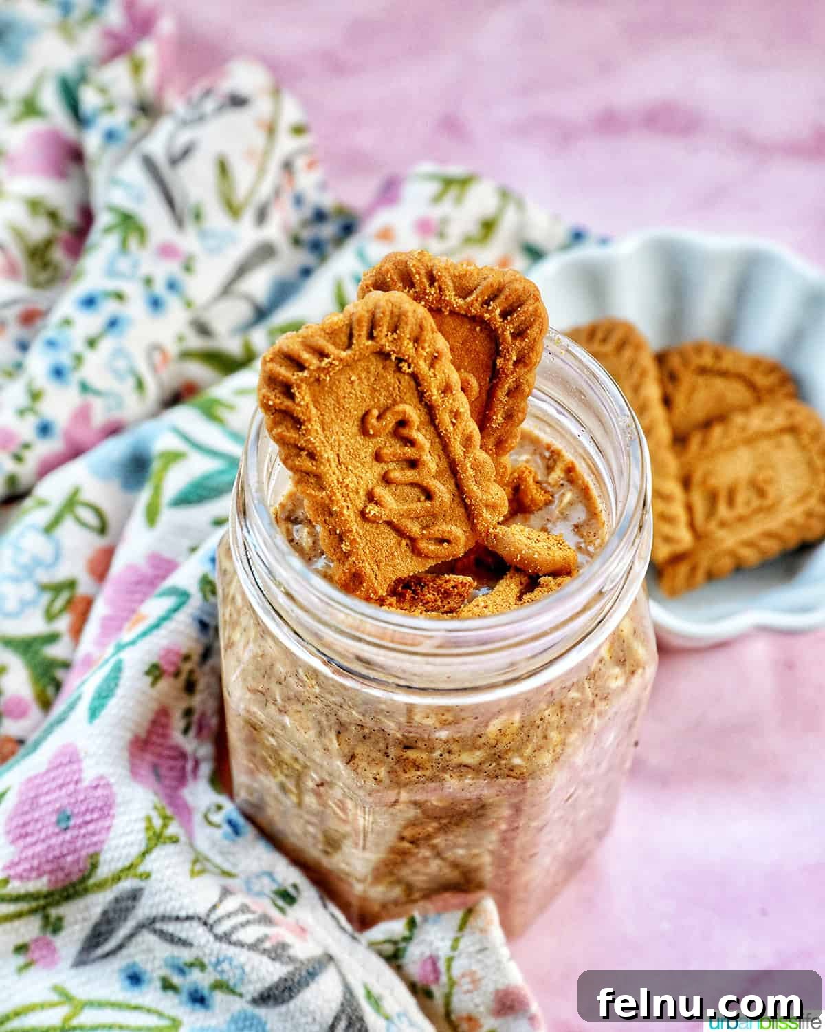 Biscoff overnight oats in a jar topped with crumbled Biscoff cookies.