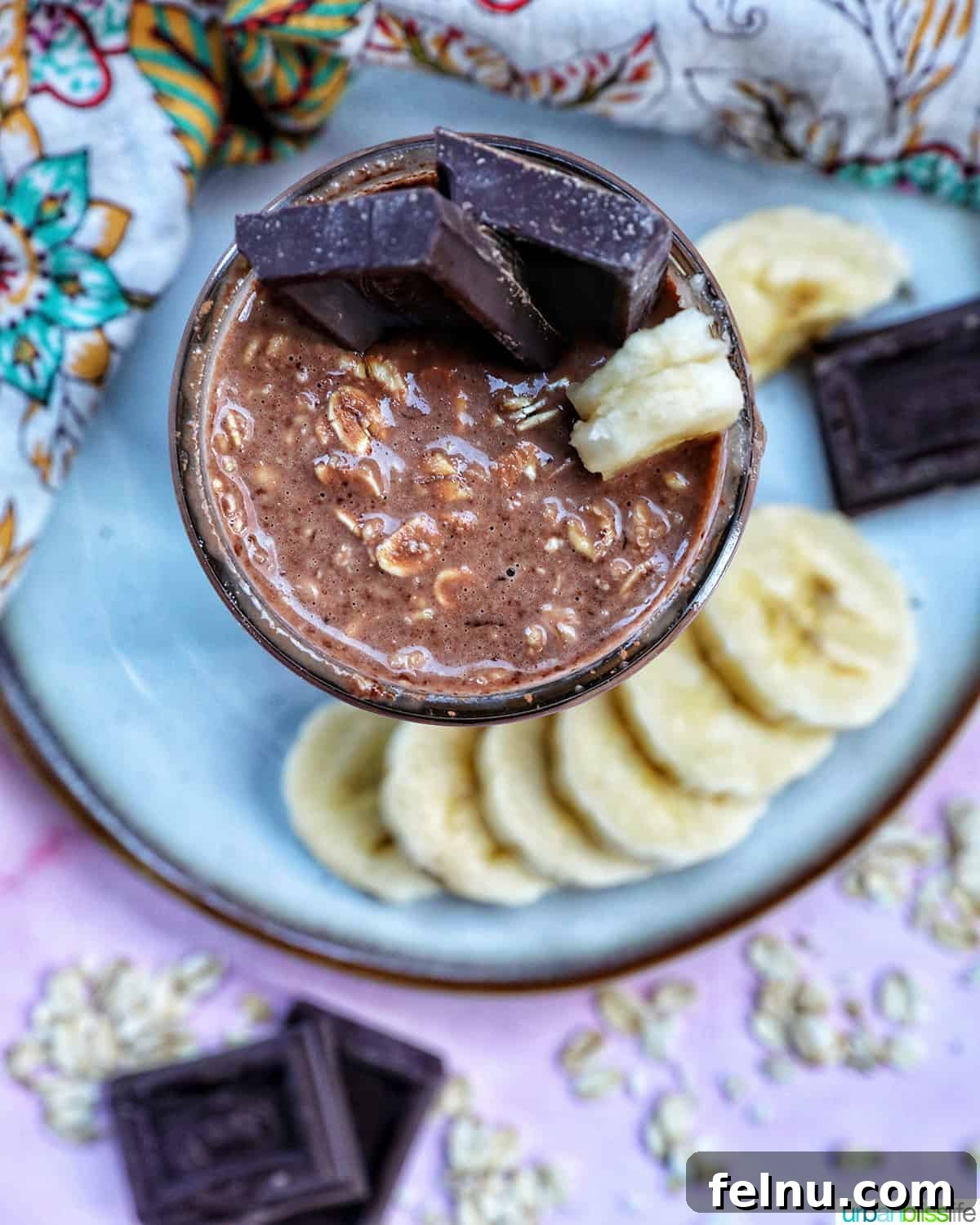 Chocolate Protein Power Oats 8 Chocolate protein overnight oats topped with banana slices and chocolate pieces.