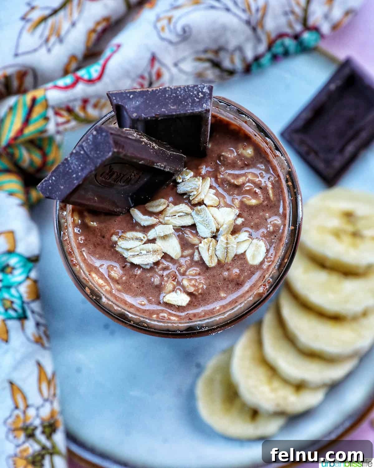 Chocolate Protein Power Oats 9 Chocolate protein overnight oats topped with banana slices and chocolate pieces.