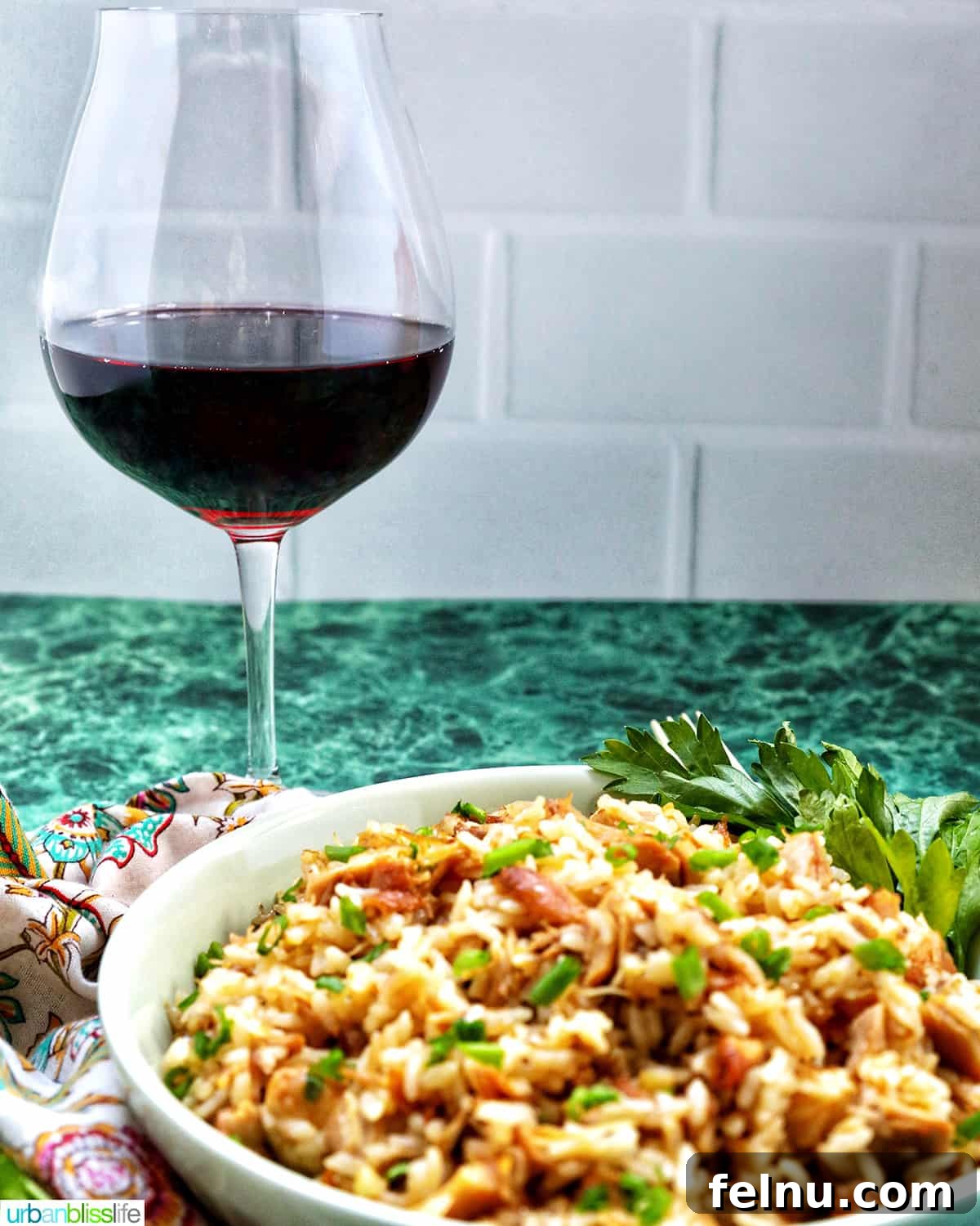 Savory Garlic Adobo Fried Rice 13 A glass of red wine positioned behind a bowl of Adobo Fried Rice, suggesting a perfect pairing.
