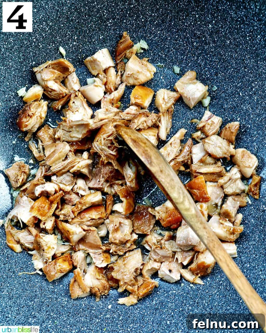 Savory Garlic Adobo Fried Rice 8 A wooden spoon stirring adobo chicken in a wok, heating it through before adding other ingredients.