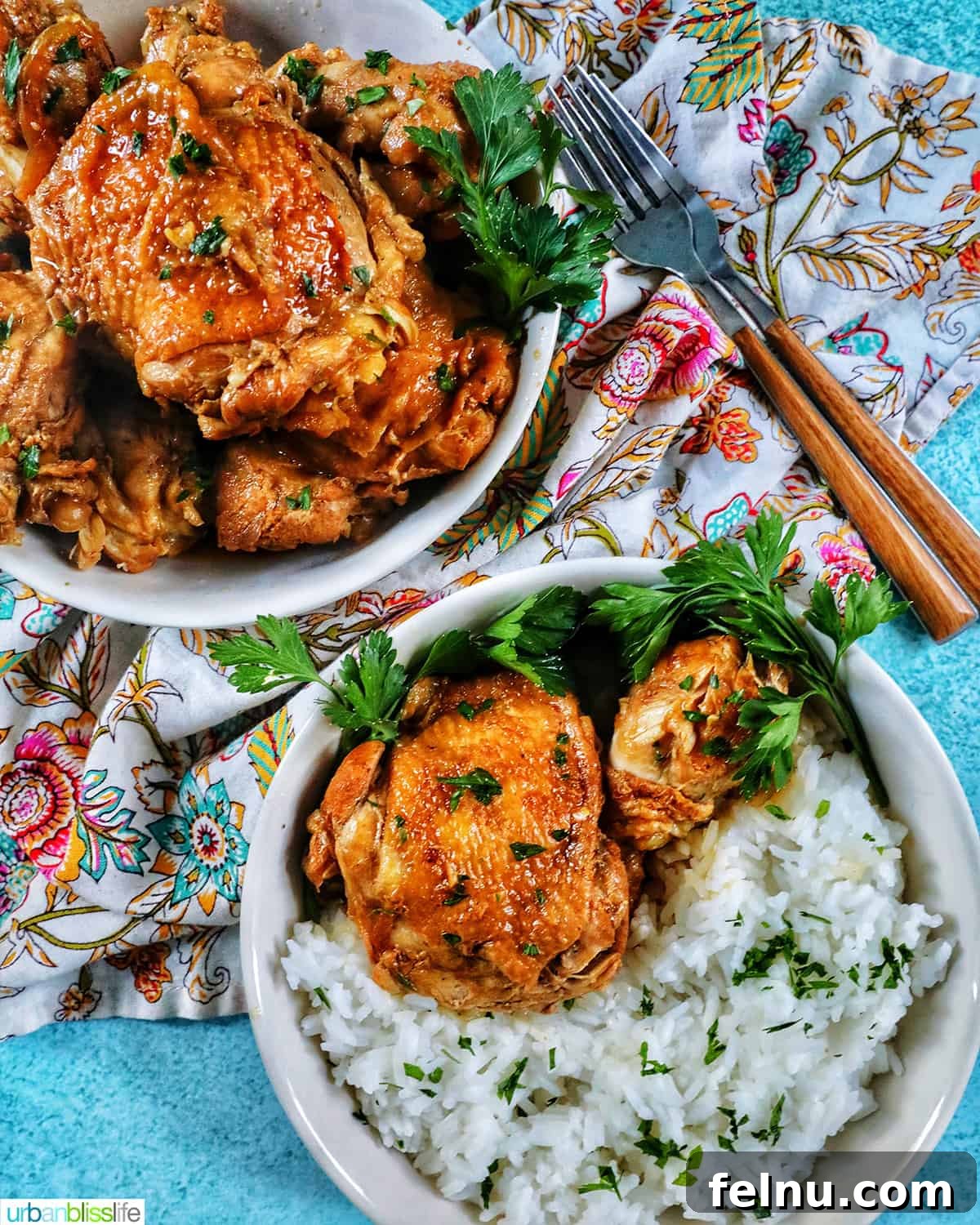Experience Filipino New Year's Eve: A Feast of Flavors and Festive Customs 5 two bowls of Instant Pot Filipino Chicken Adobo and rice, with a colorful floral napkin and forks.