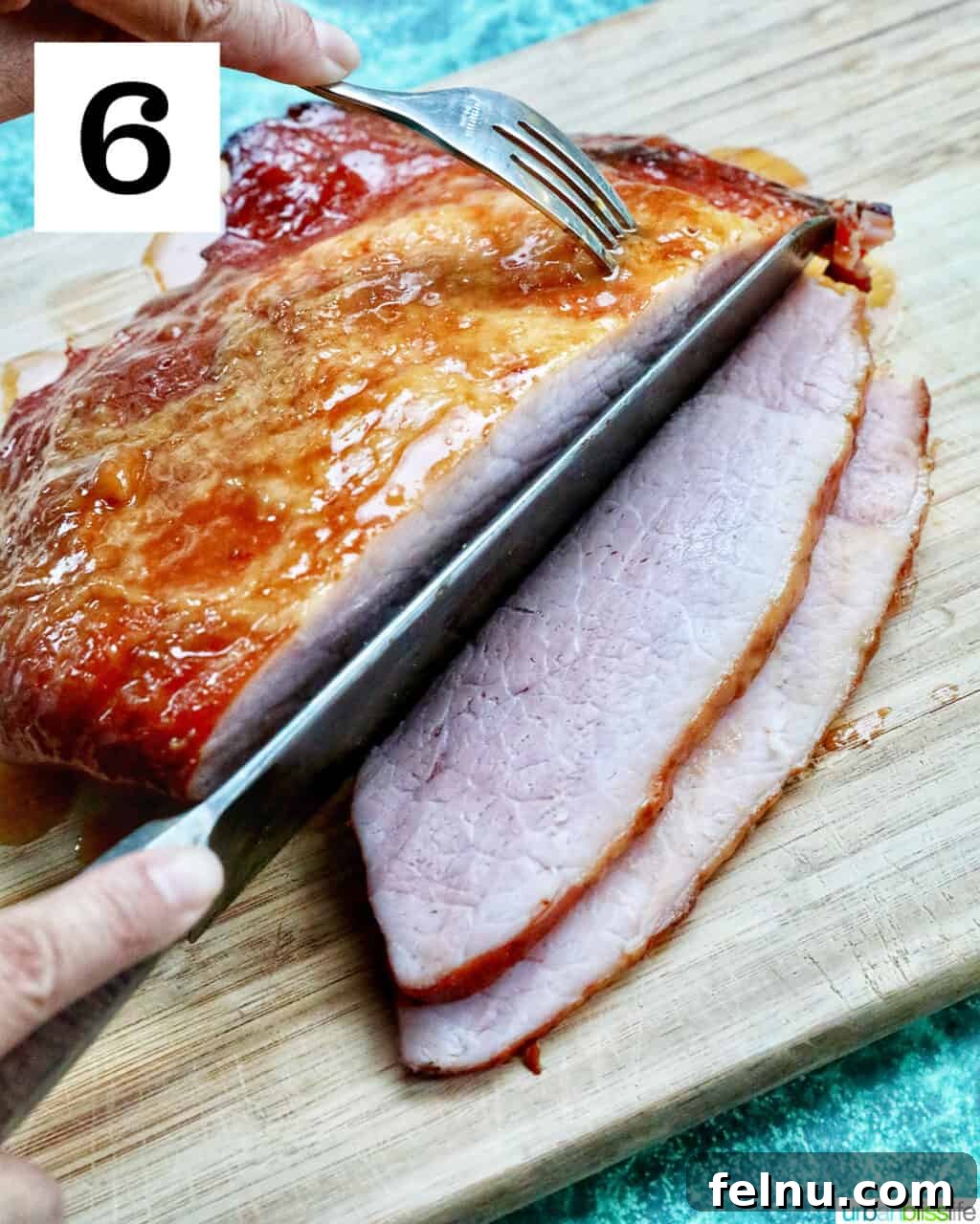Air Fryer Ham Orijinal Başlık: Crispy & Quick: Air Fryer Ham Recipe 12 Hand with knife slicing glazed ham on a cutting board