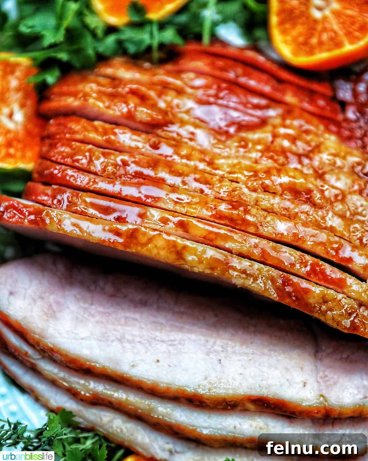 Air Fryer Ham Orijinal Başlık: Crispy & Quick: Air Fryer Ham Recipe 14 Sliced honey glazed air fryer ham on a plate with fresh herbs and sliced oranges
