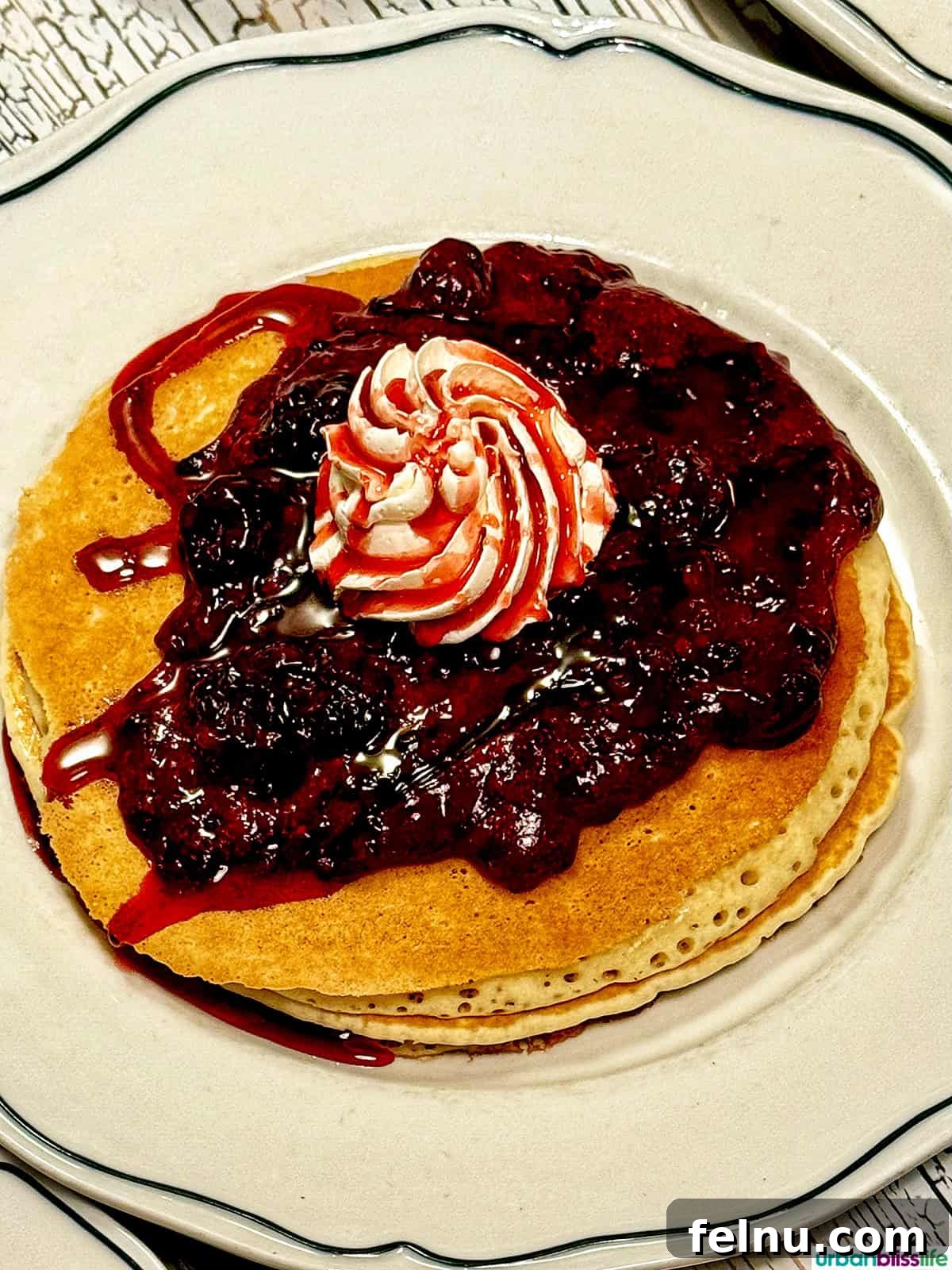 Dining Hotspots in Buena Park 14 A mouthwatering close-up of boysenberry syrup drizzled over fluffy pancakes at Thirty Acres Kitchen in Buena Park, California.
