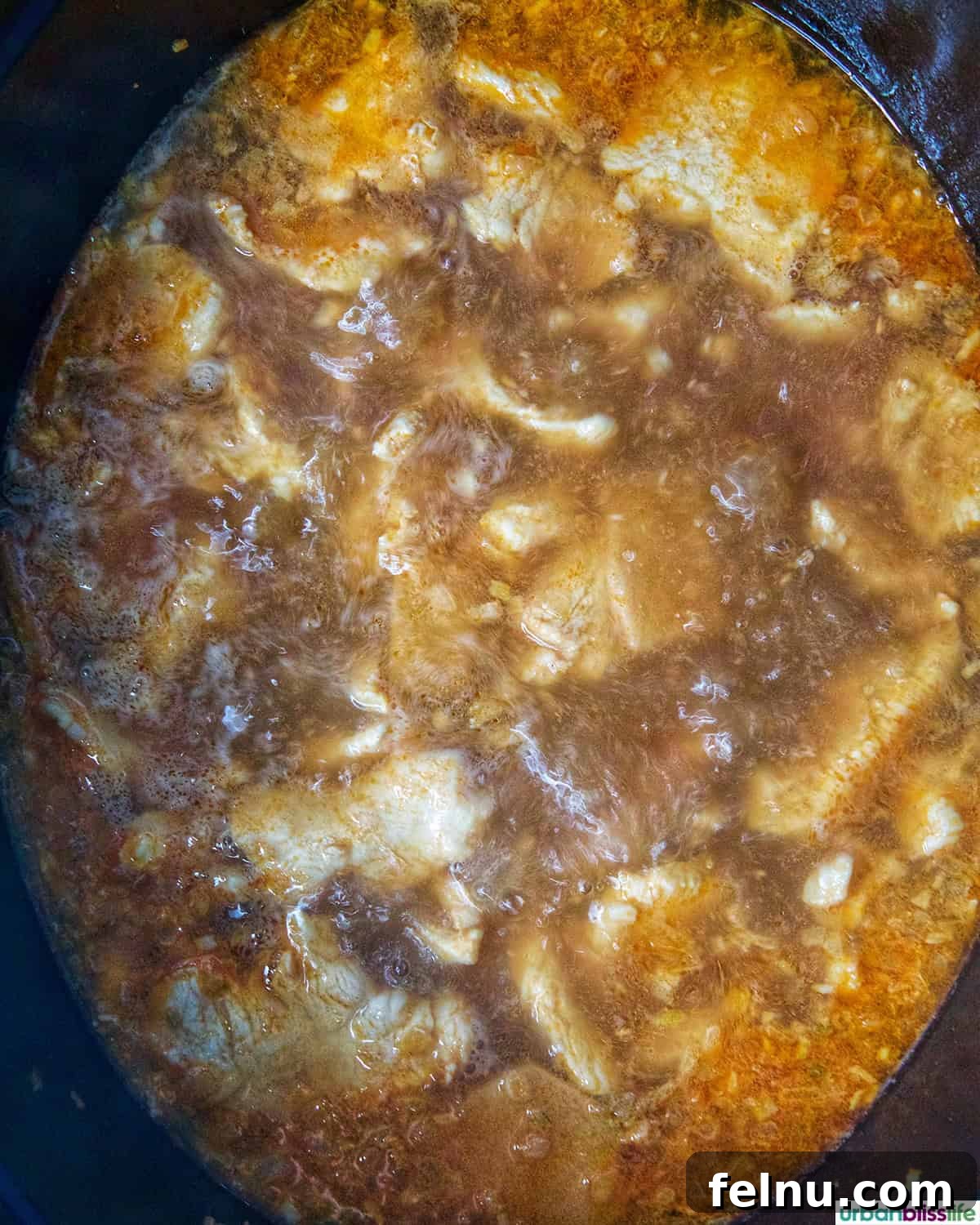 Thai Coconut Chicken Soup (Tom Kha Gai) cooking in a Dutch oven.