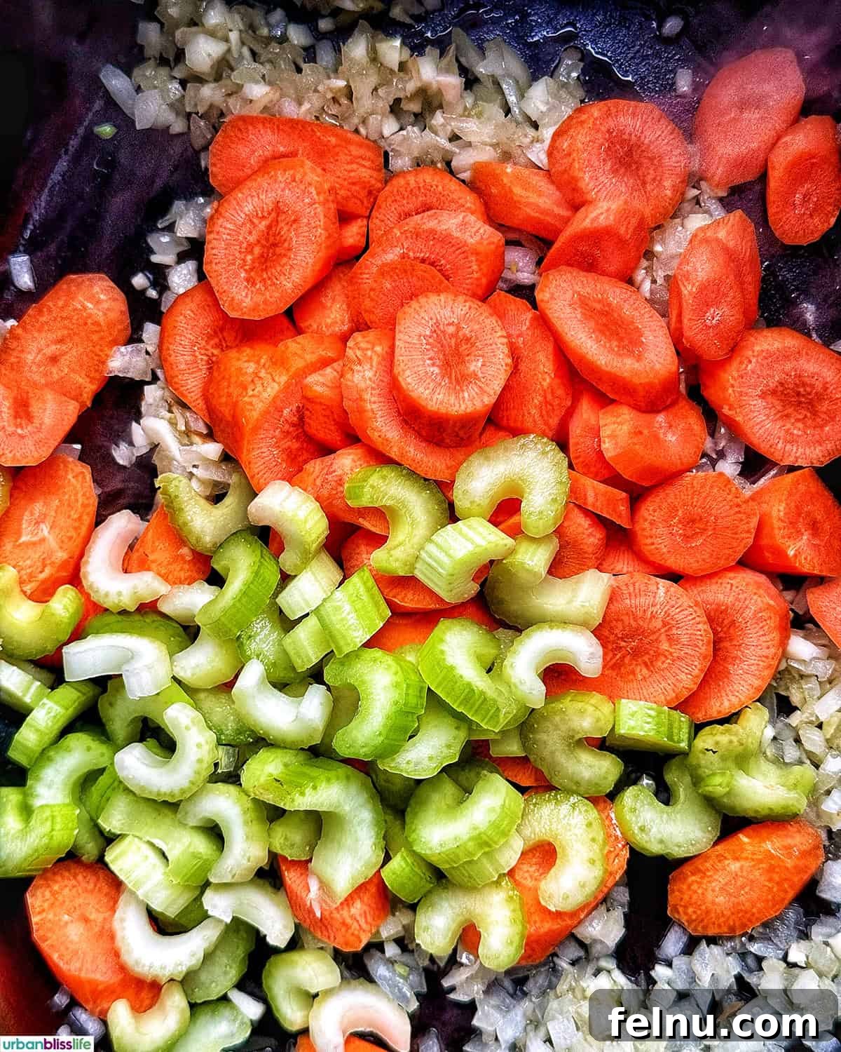 Carrots, celery, onions, and garlic cooking in a Dutch oven.