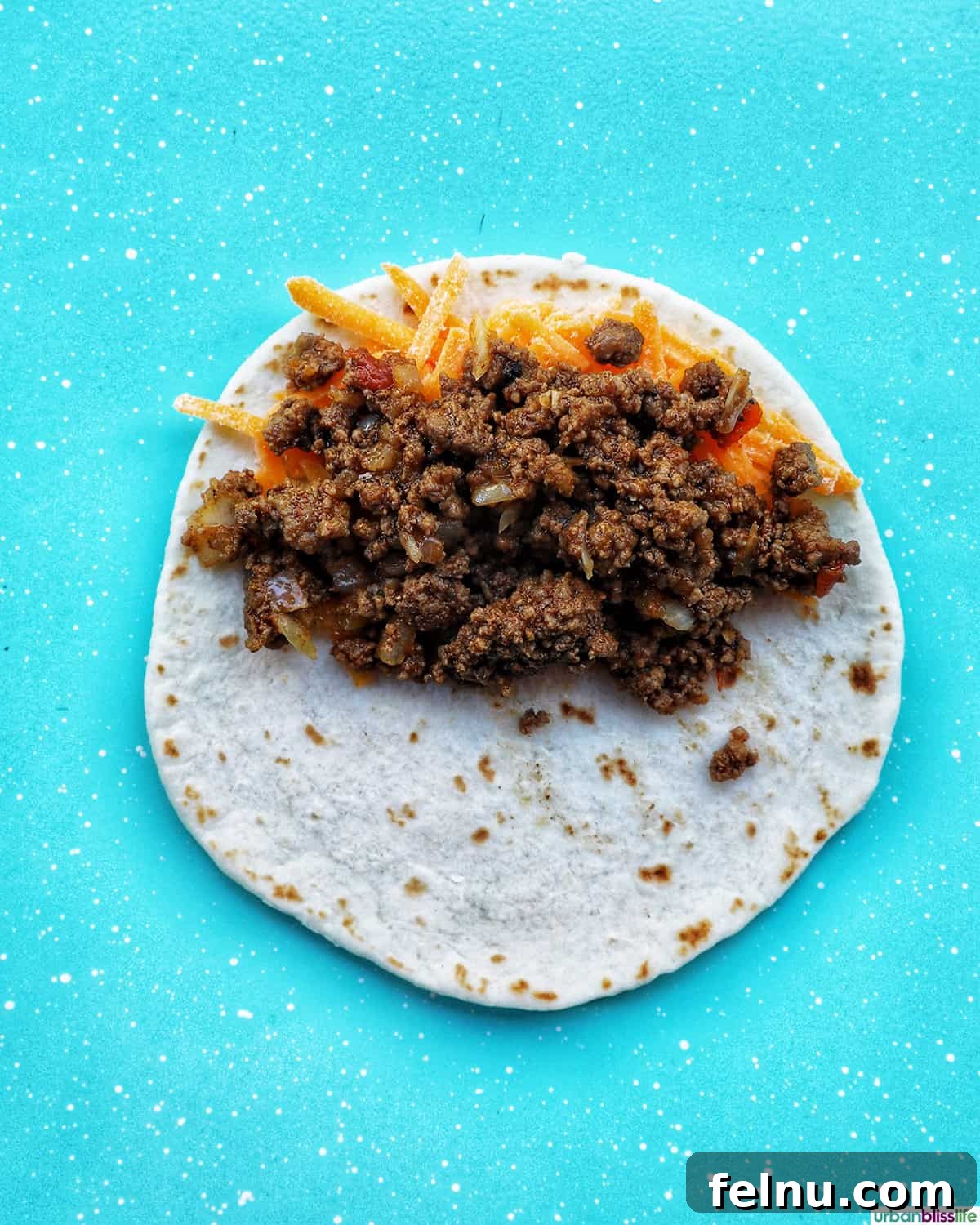 Golden-Crisp Beef Tacos 12 Seasoned ground beef placed on top of shredded cheese on a tortilla.