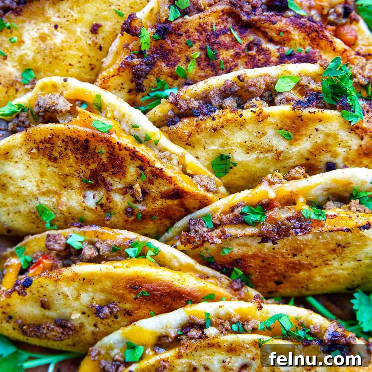 A delicious plate full of golden crispy beef tacos.
