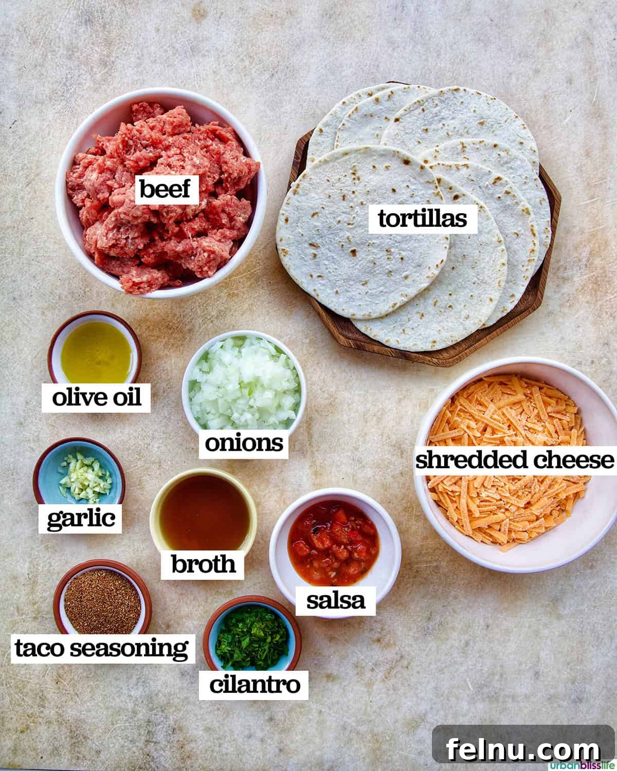 Golden-Crisp Beef Tacos 5 A selection of fresh ingredients laid out, including ground beef, onions, garlic, salsa, tortillas, and cheese, ready for making crispy beef tacos.