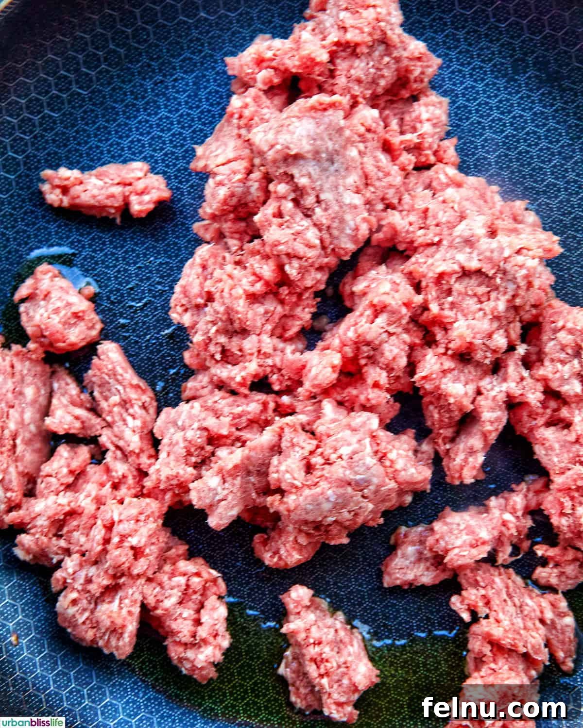 Golden-Crisp Beef Tacos 7 Ground beef browning in a pan, being broken up with a spoon.