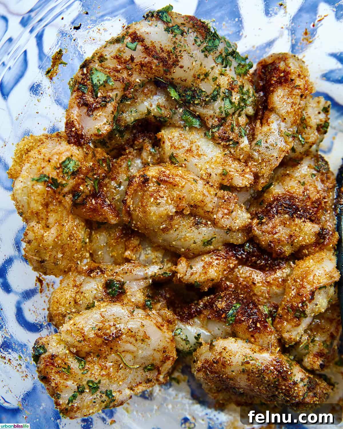 Close-up of seasoned shrimp in a bowl, showcasing the even coating of spices.
