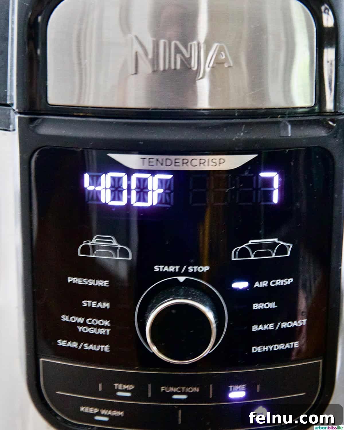 A Ninja air fryer display showing the temperature set to 400°F and a timer for 7 minutes.