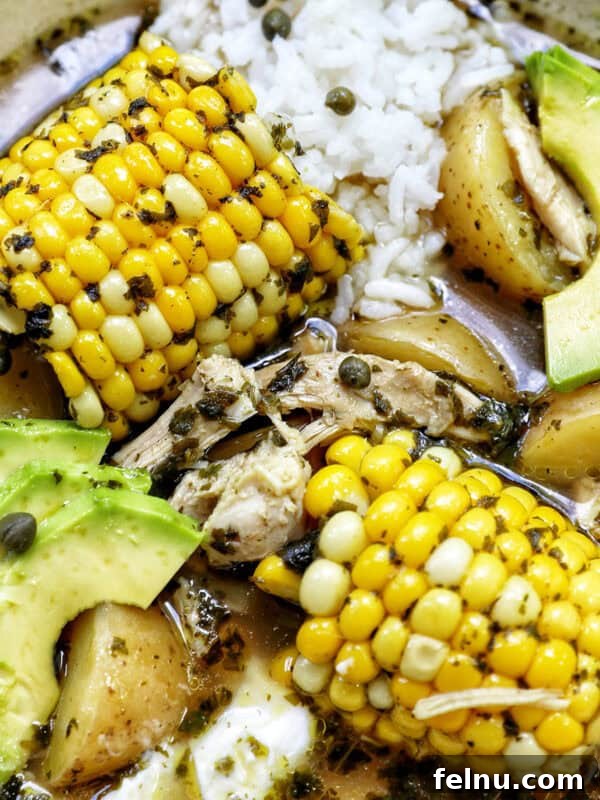 Creamy Instant Pot Mexican Corn Chowder 14 bowl of Colombian Ajiaco soup with corn on the cob and chicken, and sides of rice, avocado slices, capers, and sour cream.